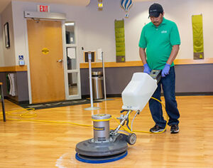 An ABS employee buffs a floor